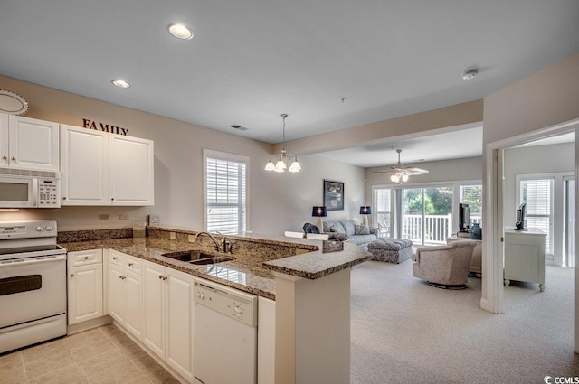 kitchen with white cabinetry, white appliances, kitchen peninsula, and sink