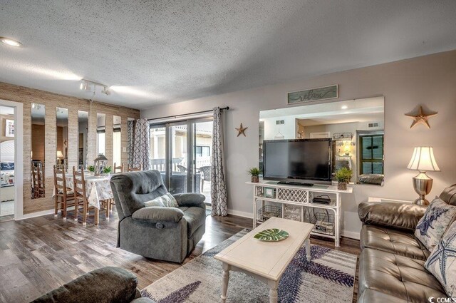 living room with hardwood / wood-style flooring, a textured ceiling, and track lighting