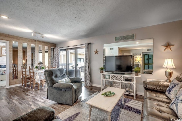 living room featuring hardwood / wood-style flooring, track lighting, and a textured ceiling