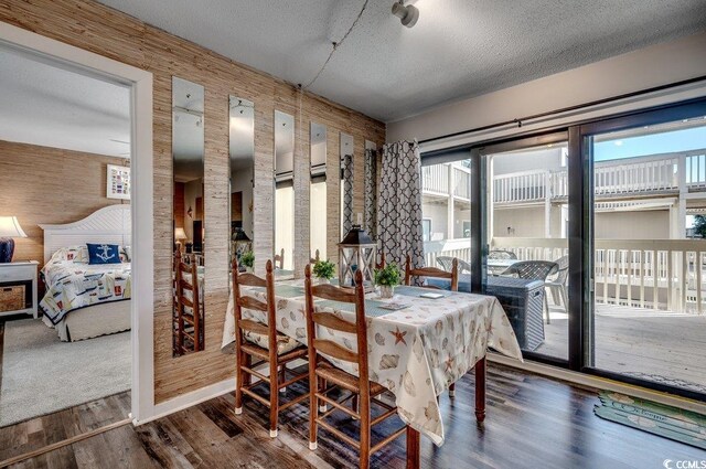 dining room with a textured ceiling and wooden walls