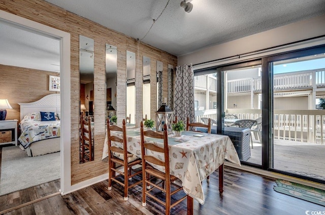 dining room with wooden walls and a textured ceiling