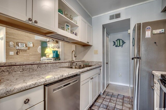 kitchen featuring light stone countertops, stainless steel appliances, white cabinetry, and sink