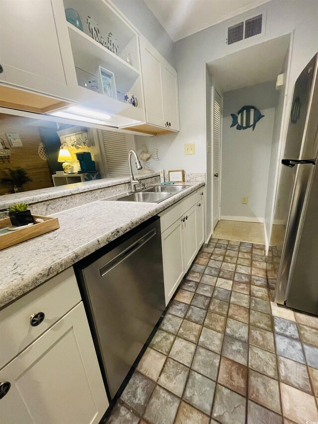 kitchen featuring white cabinets, appliances with stainless steel finishes, sink, and light stone counters