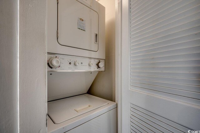 clothes washing area with stacked washer and dryer