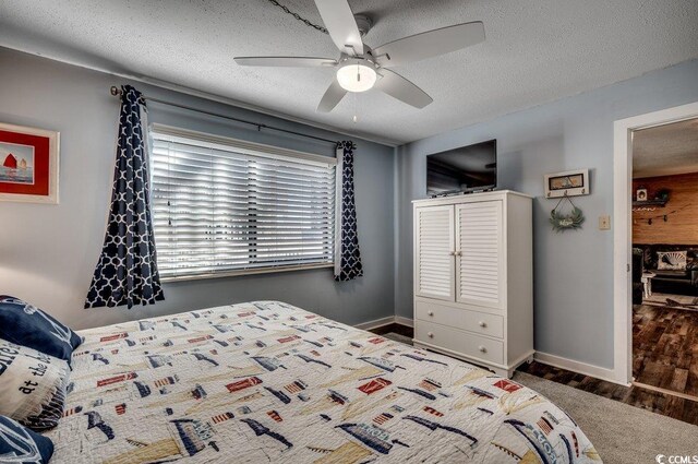 carpeted bedroom with a textured ceiling and ceiling fan