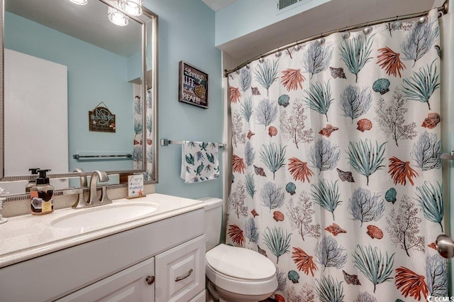 bathroom featuring vanity, toilet, and curtained shower