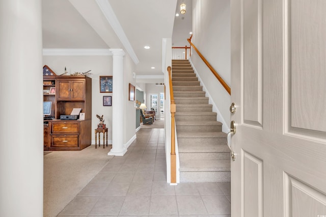 carpeted entrance foyer with crown molding and ornate columns