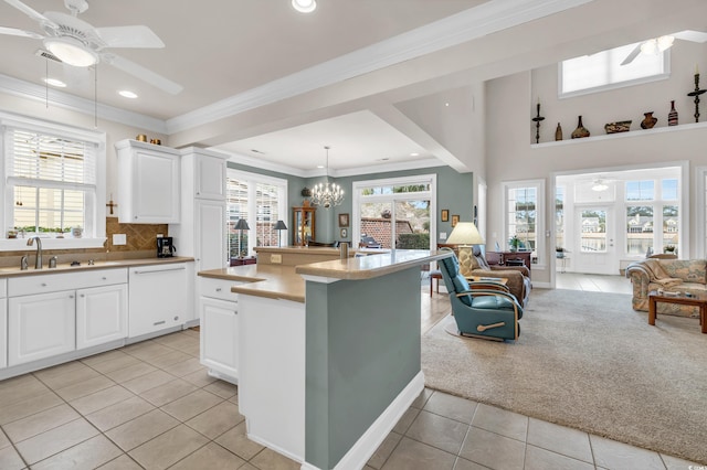 kitchen with dishwasher, decorative light fixtures, white cabinetry, light tile patterned flooring, and sink