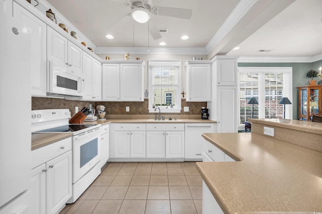 kitchen with white appliances, decorative backsplash, plenty of natural light, and white cabinets