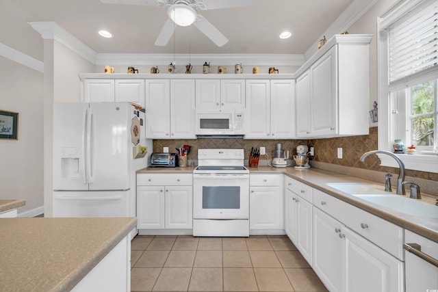 kitchen featuring white appliances, white cabinets, and sink