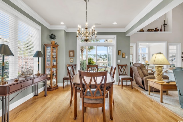 dining area featuring ornamental molding, an inviting chandelier, and light wood-type flooring