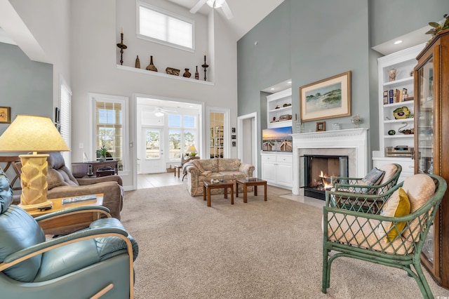 carpeted living room featuring a towering ceiling and ceiling fan