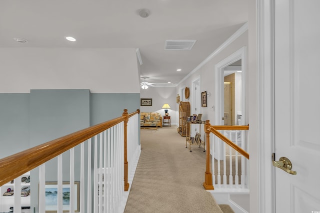 corridor with ornamental molding and light colored carpet