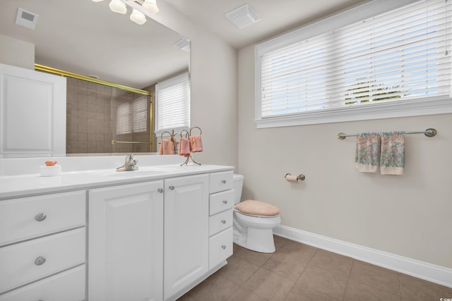 bathroom with a shower with door, tile patterned floors, vanity, and toilet