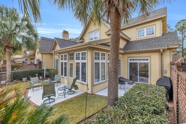 rear view of property with a patio and a yard