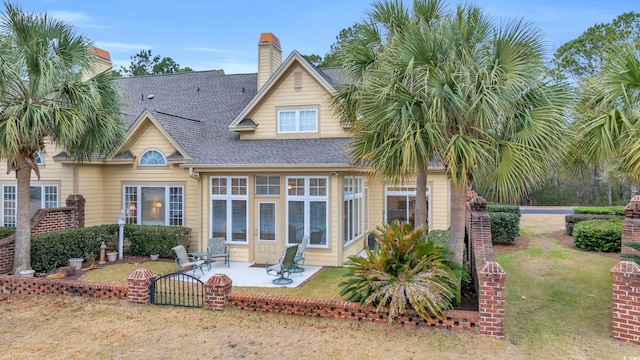 rear view of house with a patio area and a lawn