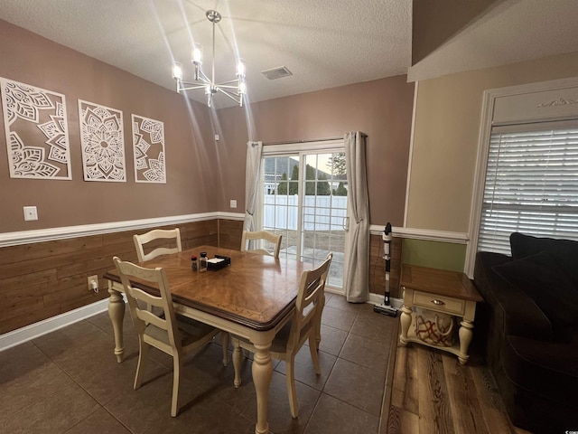 389 Cabo Loop, Myrtle Beach, SC 29588 - tiled dining room featuring a chandelier, a wainscoted wall, a textured ceiling, and wood walls