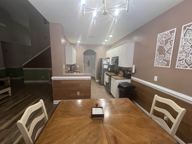 living room with ceiling fan with notable chandelier, high vaulted ceiling, and dark hardwood / wood-style flooring