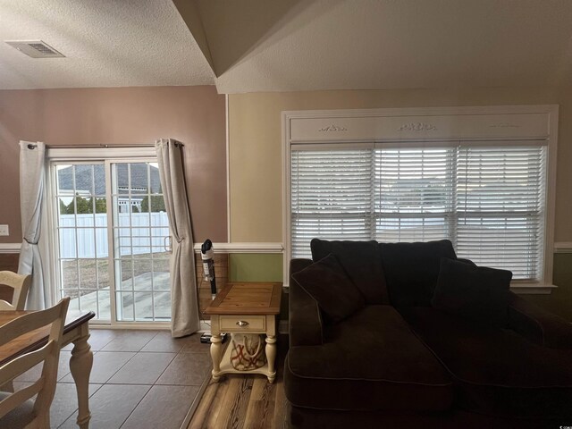 living room with a textured ceiling and light tile patterned floors