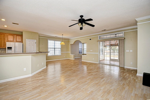 unfurnished living room featuring a textured ceiling, light wood-type flooring, ceiling fan, and crown molding