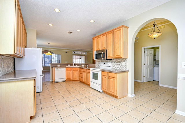 kitchen with light tile patterned floors, white appliances, backsplash, and hanging light fixtures