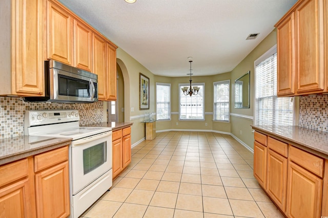 kitchen featuring white electric range, an inviting chandelier, backsplash, and light tile patterned floors