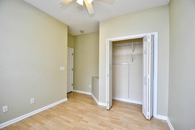 unfurnished bedroom featuring a closet, a textured ceiling, ceiling fan, and light wood-type flooring