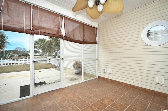 unfurnished sunroom featuring ceiling fan