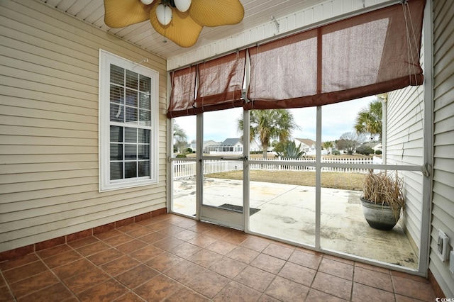 unfurnished sunroom featuring ceiling fan