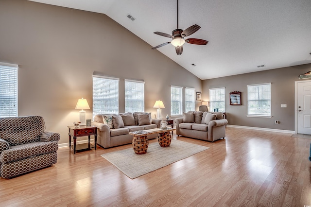 living room with high vaulted ceiling, ceiling fan, and light wood-type flooring