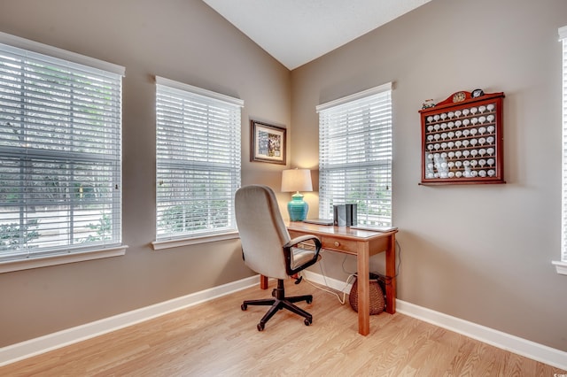 office with light wood-type flooring and lofted ceiling