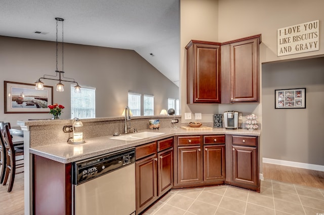 kitchen featuring dishwasher, light tile patterned floors, pendant lighting, sink, and lofted ceiling