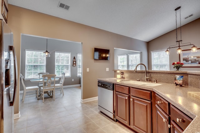 kitchen featuring vaulted ceiling, hanging light fixtures, stainless steel appliances, light tile patterned floors, and sink