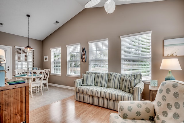 living room with lofted ceiling, ceiling fan, plenty of natural light, and light wood-type flooring