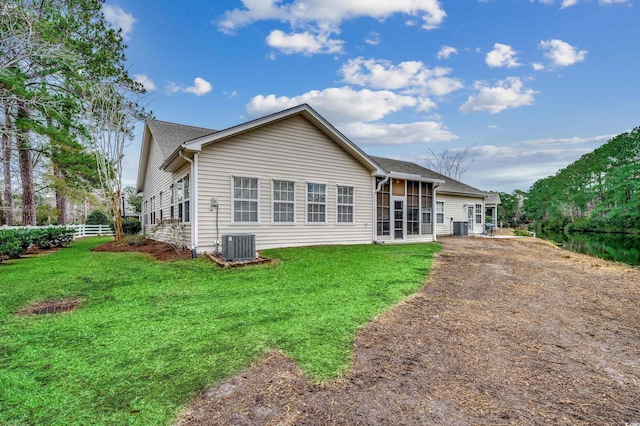 back of house with a yard, a sunroom, and central AC unit