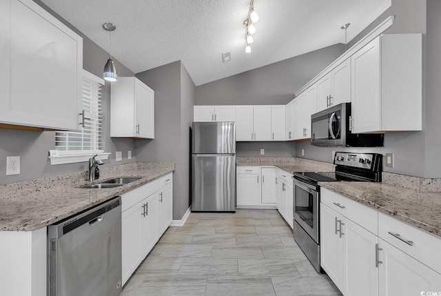 kitchen with white cabinets, appliances with stainless steel finishes, and pendant lighting