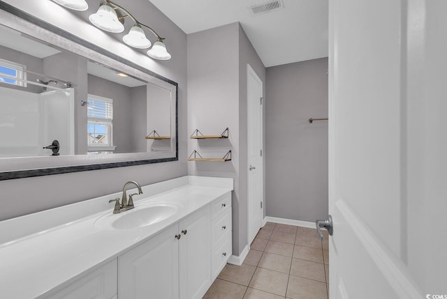 bathroom with walk in shower, tile patterned flooring, and vanity