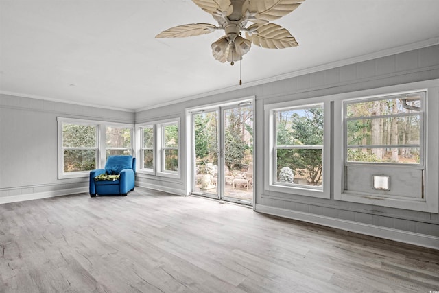 unfurnished sunroom with ceiling fan