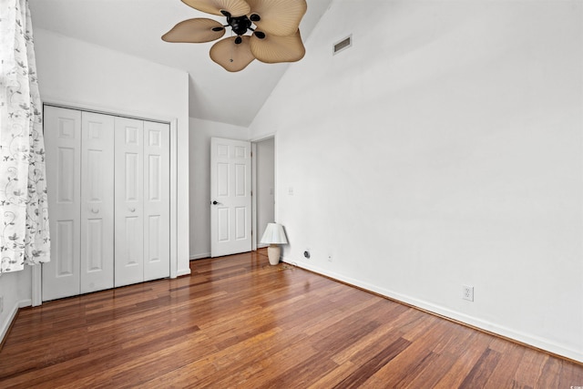 unfurnished bedroom with ceiling fan, a closet, dark hardwood / wood-style flooring, and vaulted ceiling