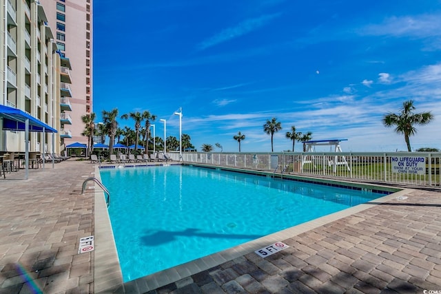 community pool featuring a patio and fence