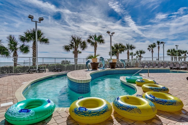 community pool featuring fence and a patio