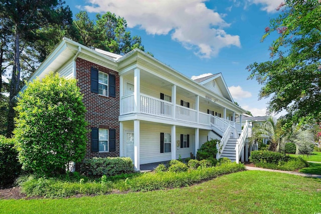 view of front of property with a balcony, a front lawn, and a porch