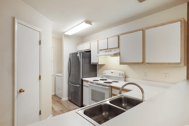 kitchen featuring washer and dryer, white cabinetry, white electric stove, sink, and stainless steel fridge