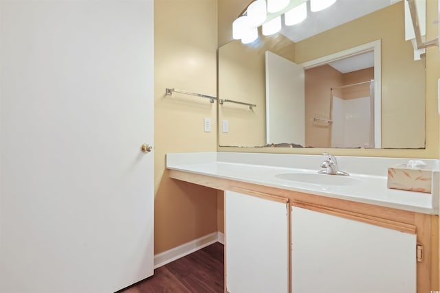 bathroom with wood-type flooring, walk in shower, and vanity