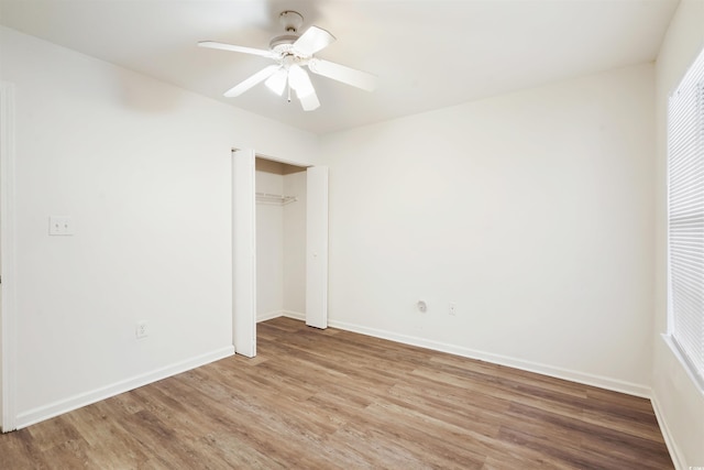 unfurnished bedroom featuring ceiling fan, a closet, and hardwood / wood-style floors