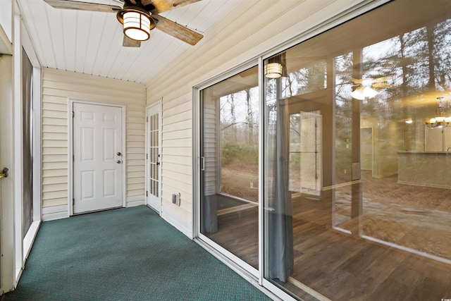 unfurnished sunroom featuring ceiling fan