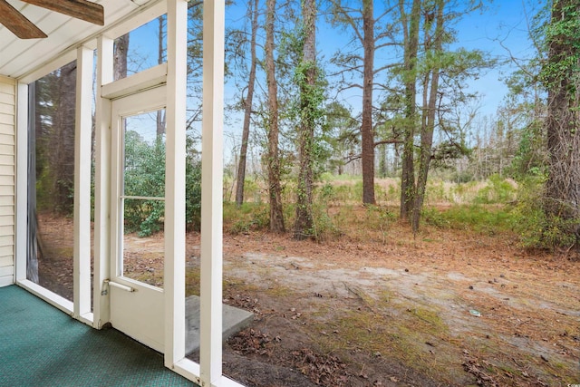 exterior space featuring ceiling fan, carpet floors, and beam ceiling