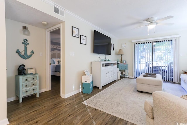 living room featuring ornamental molding, dark wood-type flooring, and ceiling fan