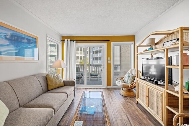 living room featuring a textured ceiling, ornamental molding, and hardwood / wood-style flooring