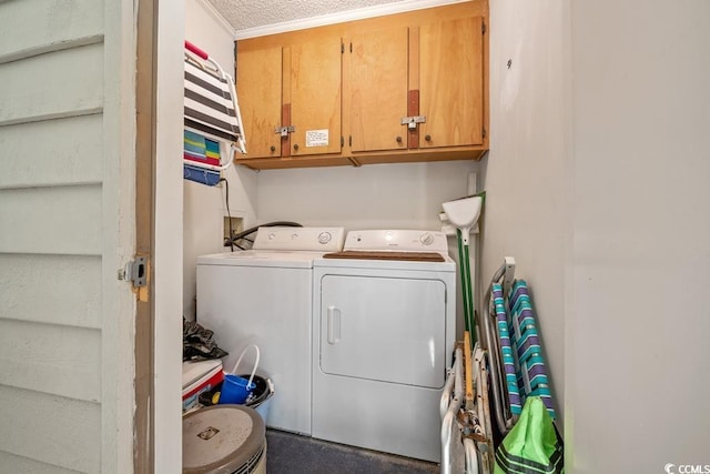 washroom featuring a textured ceiling, separate washer and dryer, and cabinets